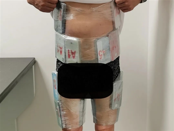 一男子身穿手机“铠甲”入境被查：全身裹满52部旧iPhone 男子身穿手机铠甲 第1张